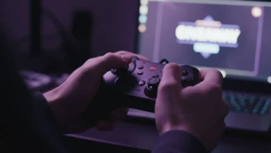Mains crispées sur une manette de jeu devant un écran affichant une notification suspecte dans une pièce sombre